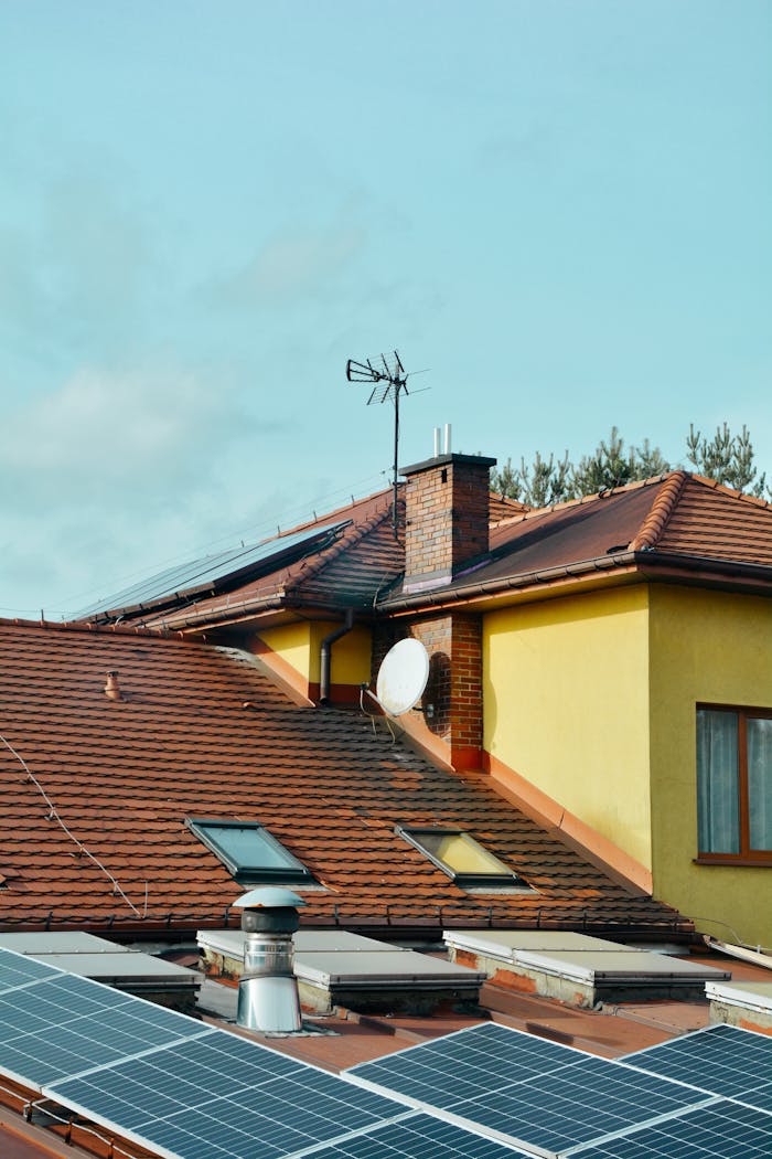 Yellow building with solar panels and antennas on rooftop in Poland. Eco-friendly technology.